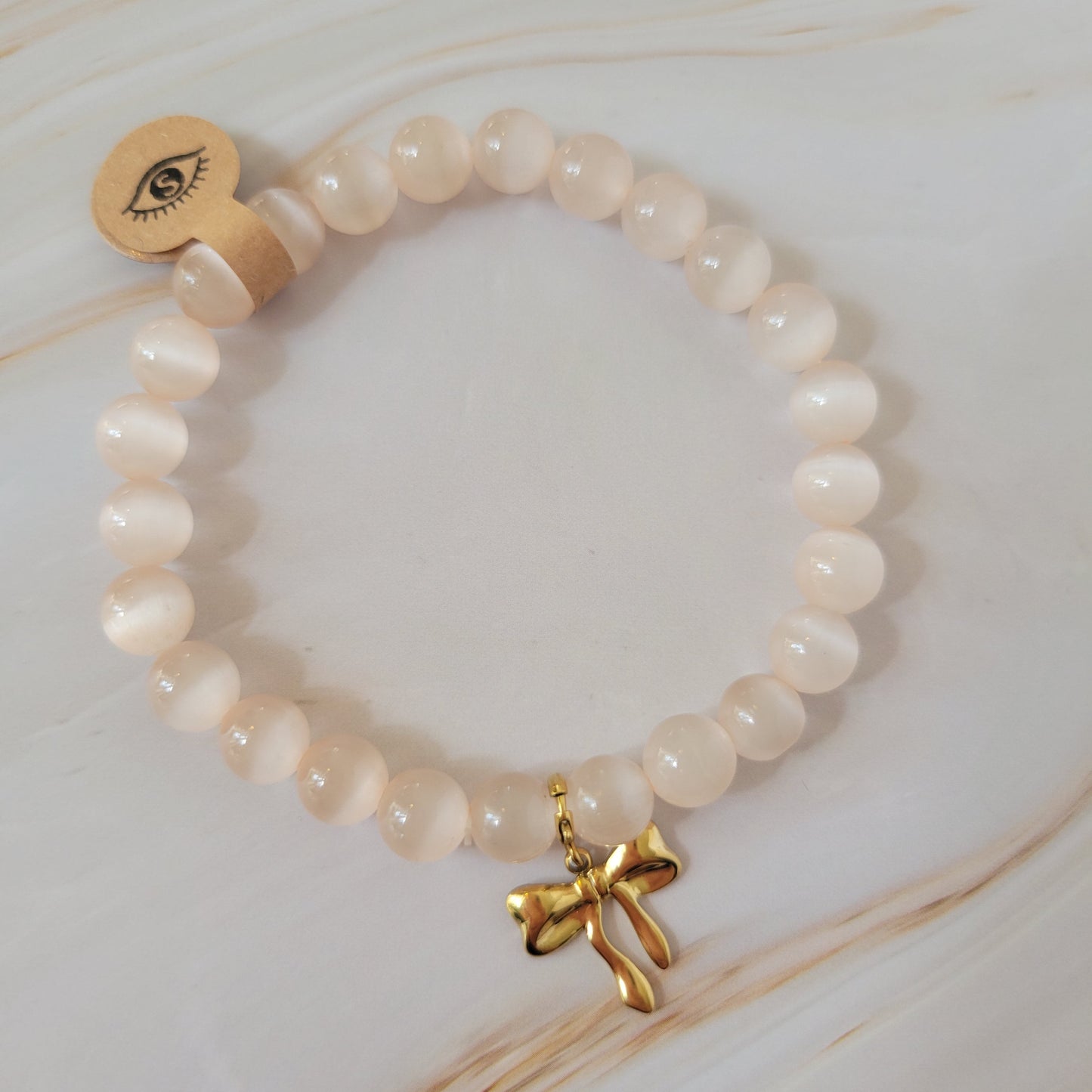 Armband mit natürlichem Cat's Eye Stein – weiß / rosé schimmer mit Schleifen Bowtie Charm