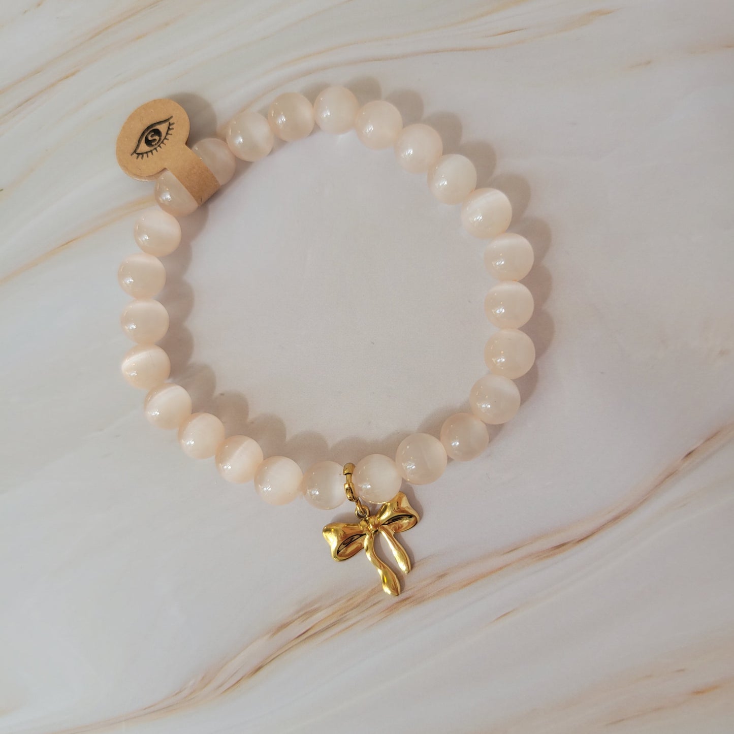 Armband mit natürlichem Cat's Eye Stein – weiß / rosé schimmer mit Schleifen Bowtie Charm